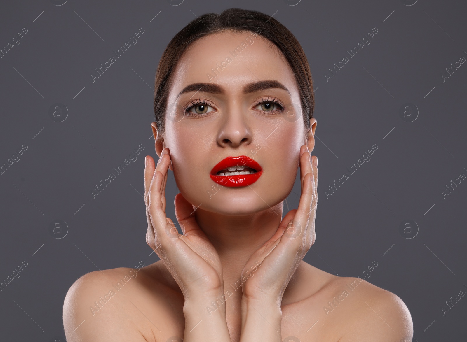 Photo of Young woman with red lips makeup on grey background