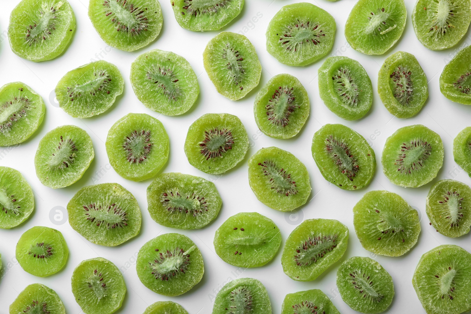 Photo of Slices of kiwi on white background, flat lay. Dried fruit as healthy food