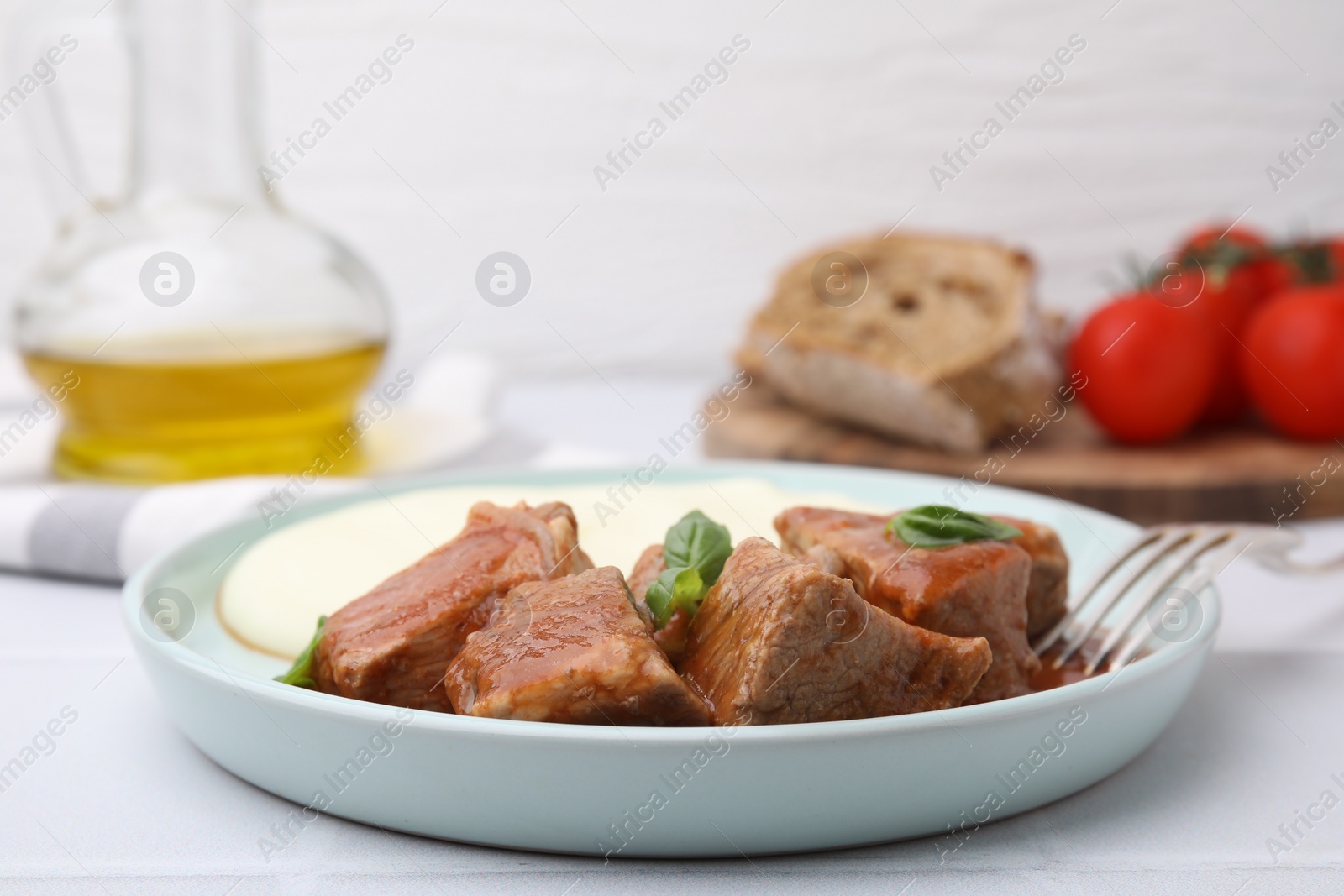Photo of Delicious goulash served with mashed potato on white table, closeup