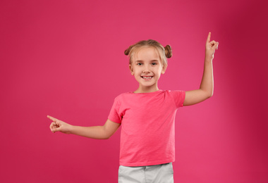 Photo of Cute little girl posing on pink background