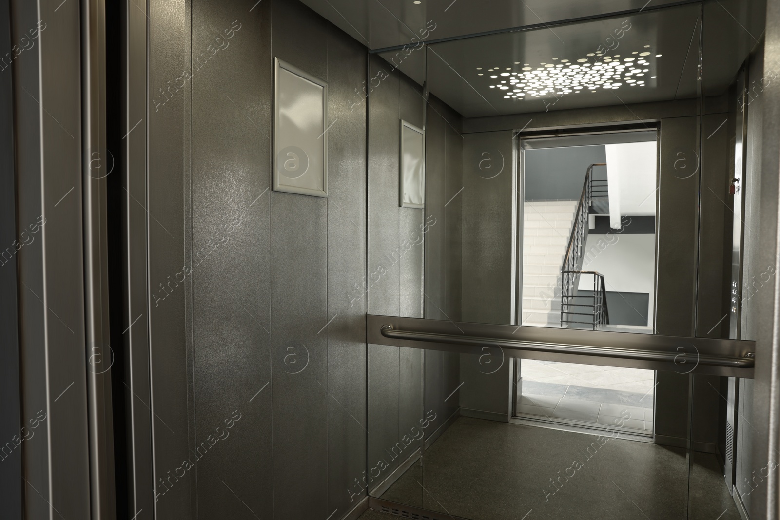 Photo of Open elevator`s cabin with big mirror indoors