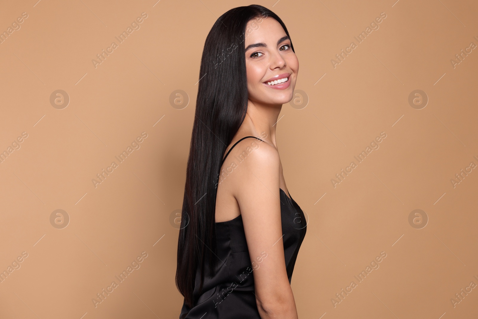 Photo of Portrait of beautiful young woman with healthy strong hair on beige background