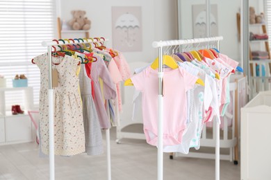 Photo of Baby clothes hanging on rack in store. Shopping concept