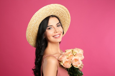 Photo of Portrait of smiling woman with beautiful bouquet on pink background