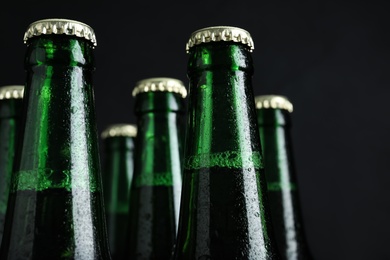 Photo of Bottles of beer on black background, closeup
