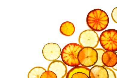 Illuminated slices of citrus fruits on white background, top view