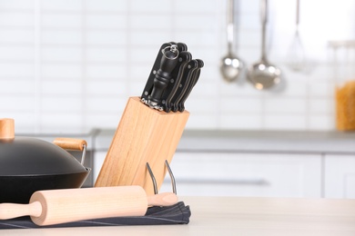 Photo of Set of clean cookware and utensils on table in kitchen. Space for text