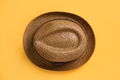 Photo of Stylish straw hat on orange background, top view