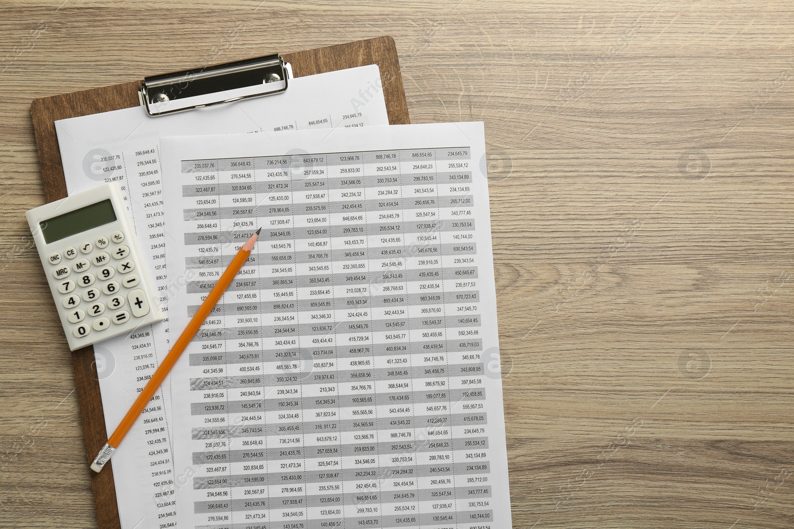 Photo of Accounting documents, calculator, clipboard and pencil on wooden table, top view. Space for text