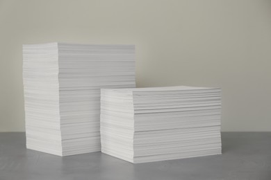 Photo of Stacks of paper sheets on grey table