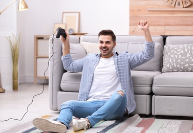 Emotional young man playing video games at home