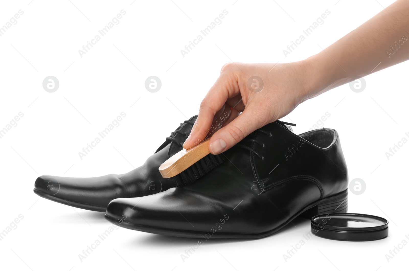 Photo of Woman cleaning stylish footwear on white background, closeup. Shoe care accessories