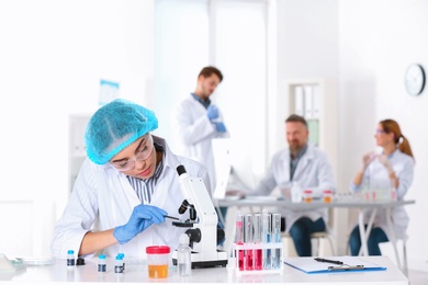 Female scientist working at table in laboratory, space for text. Research and analysis