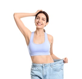 Happy young woman in big jeans showing her slim body on white background