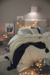 Photo of Cozy bedroom interior with warm blanket and cushions