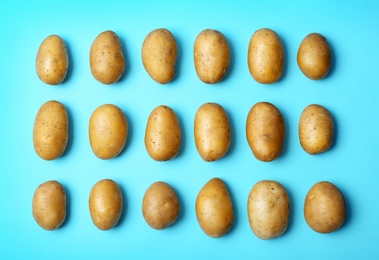 Flat lay composition with fresh ripe organic potatoes on color background