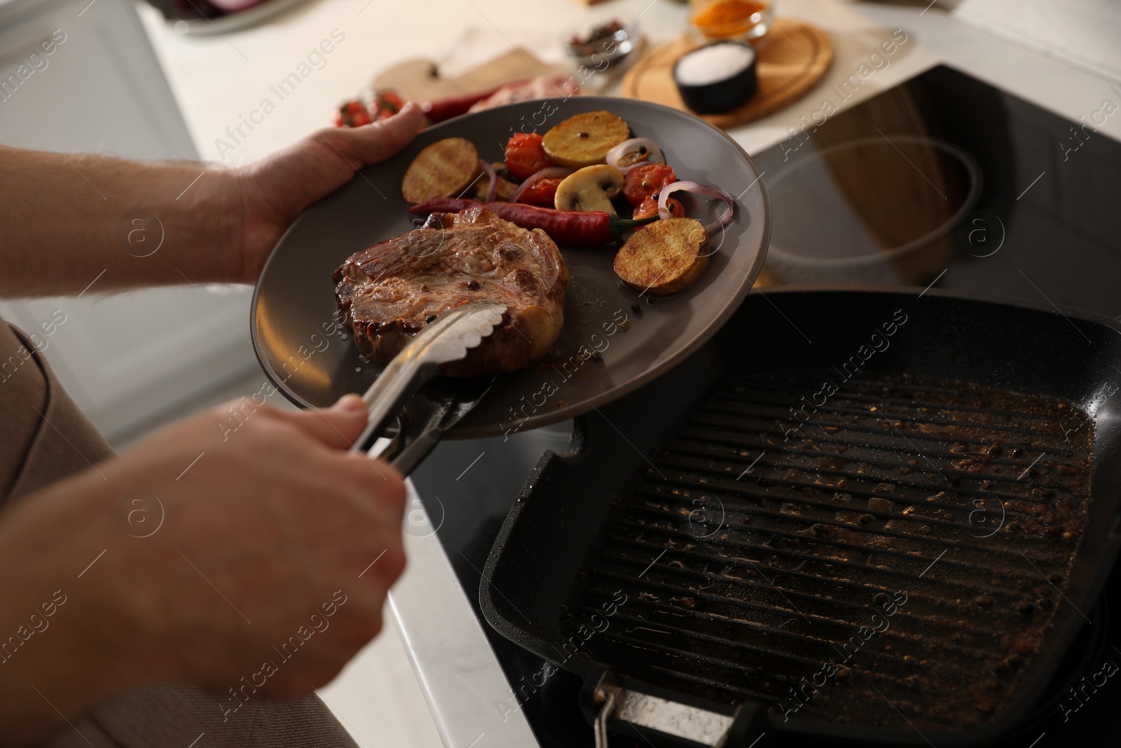 Photo of Man with tasty meat and vegetables cooked on frying pan, closeup