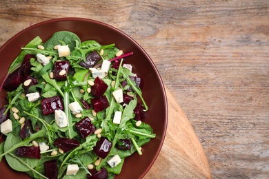 Fresh delicious beet salad on wooden table, top view. Space for text