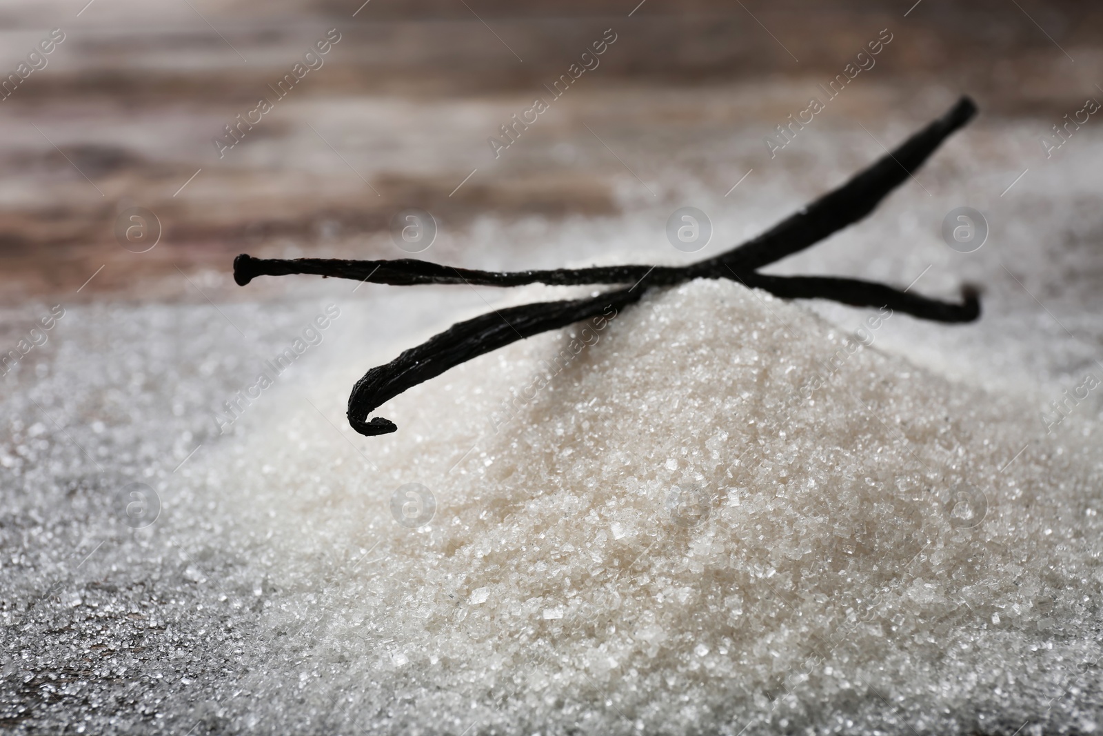 Photo of Vanilla sugar and sticks on table, closeup