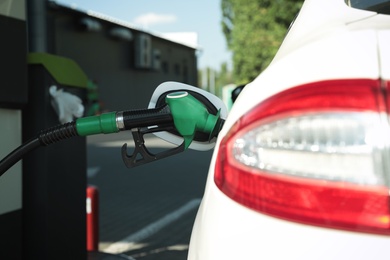 Photo of Refueling modern car with petrol pump on gas station, closeup