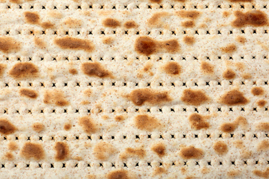 Photo of Traditional Matzo as background, top view. Pesach (Passover) celebration