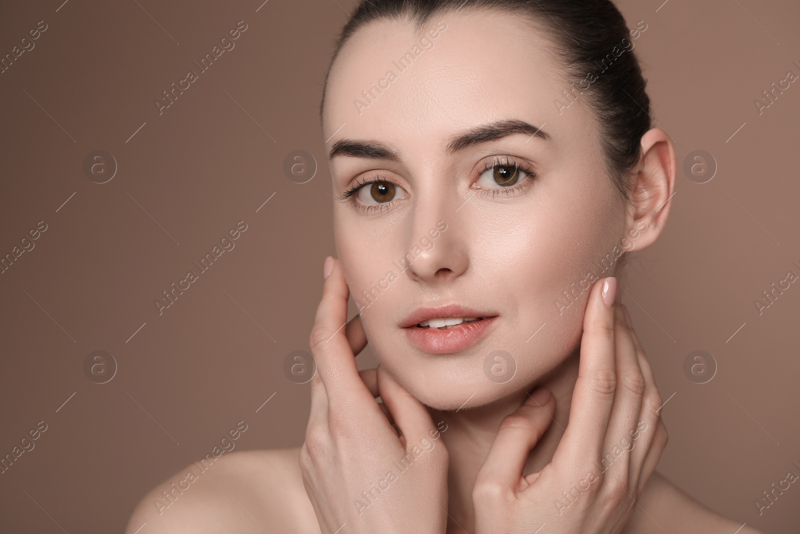 Photo of Portrait of beautiful young woman on brown background