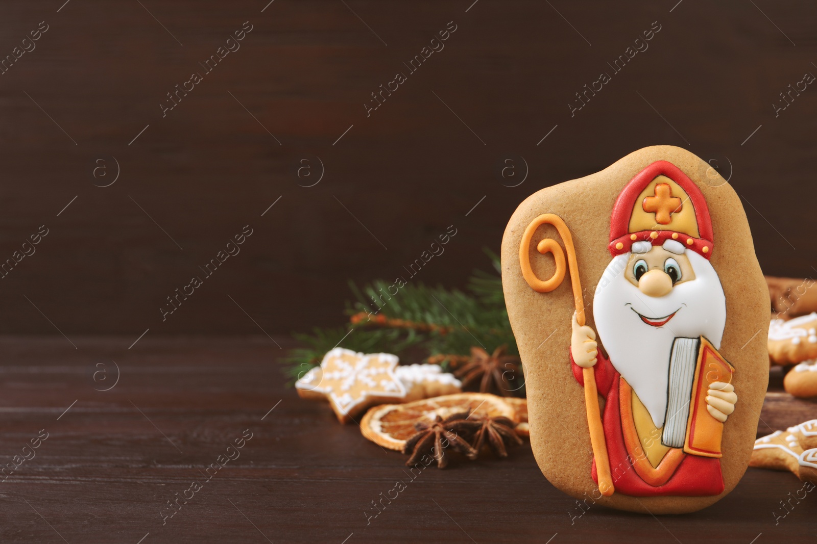 Photo of Tasty gingerbread cookies on wooden table, space for text. St. Nicholas Day celebration