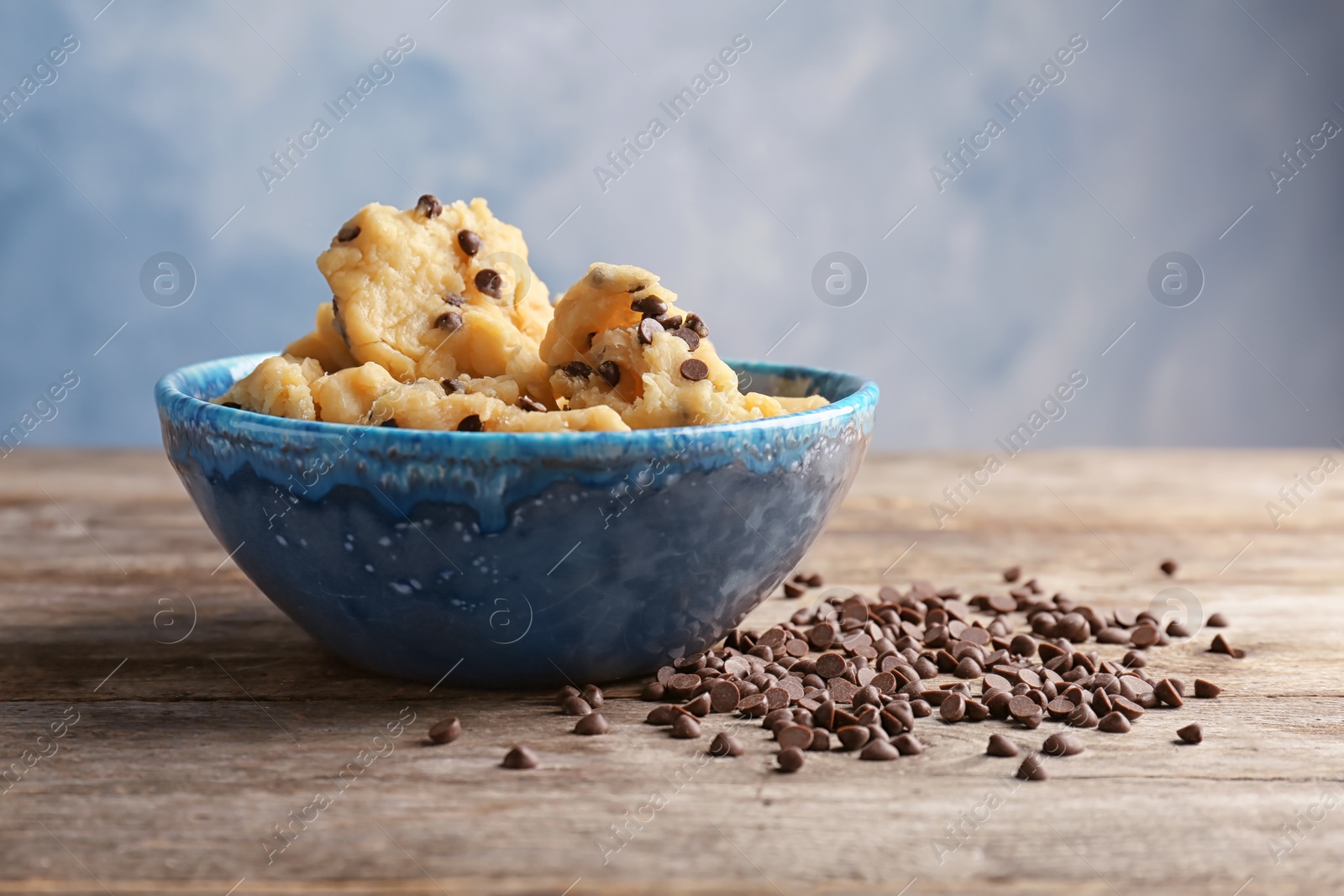 Photo of Raw cookie dough with chocolate chips in bowl on table