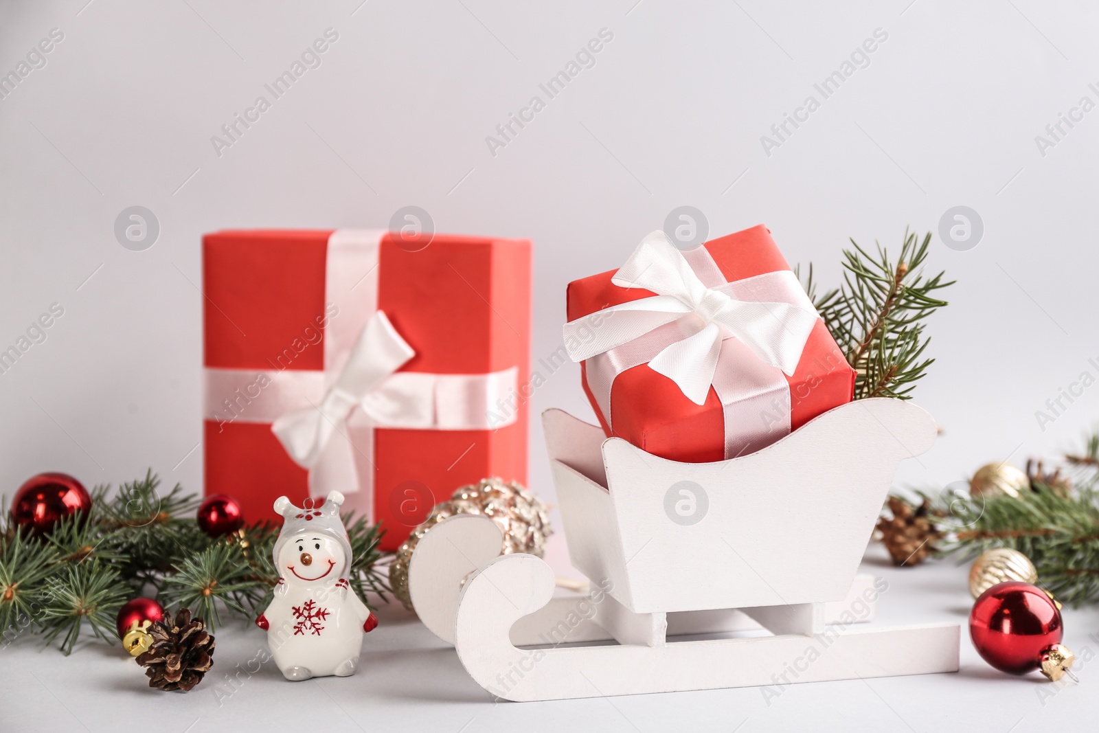 Photo of Beautiful Christmas composition with miniature sleigh on light background