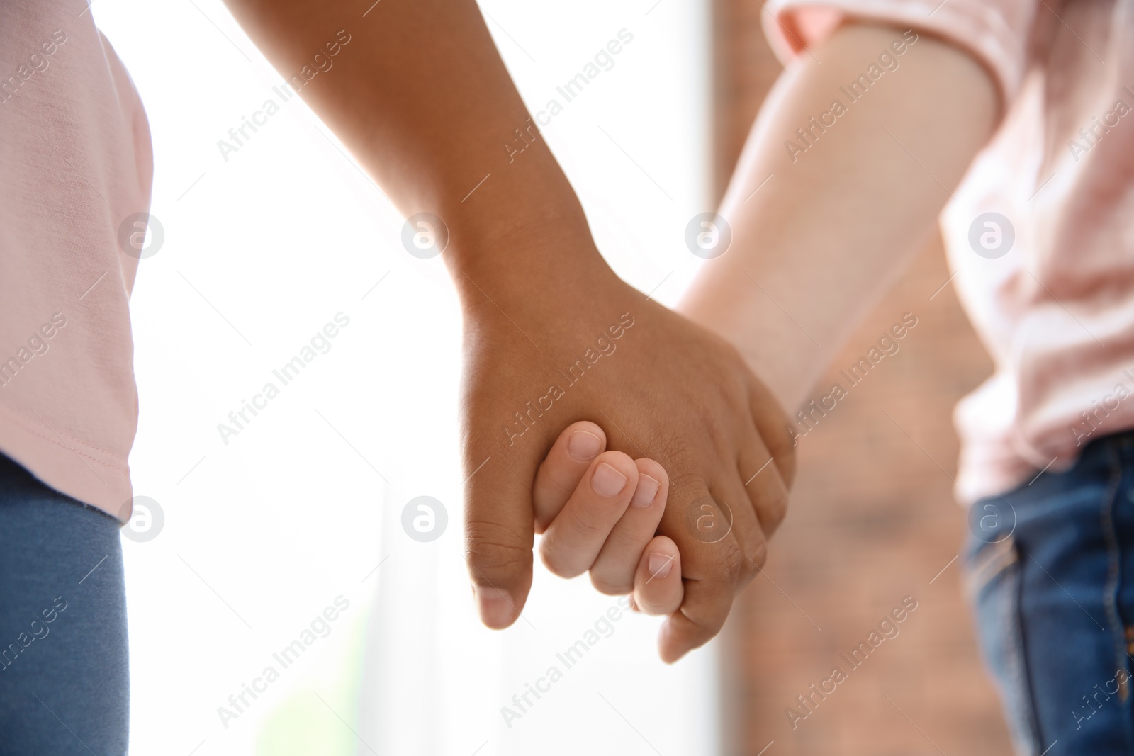 Photo of Children holding hands on blurred background, closeup. Unity concept