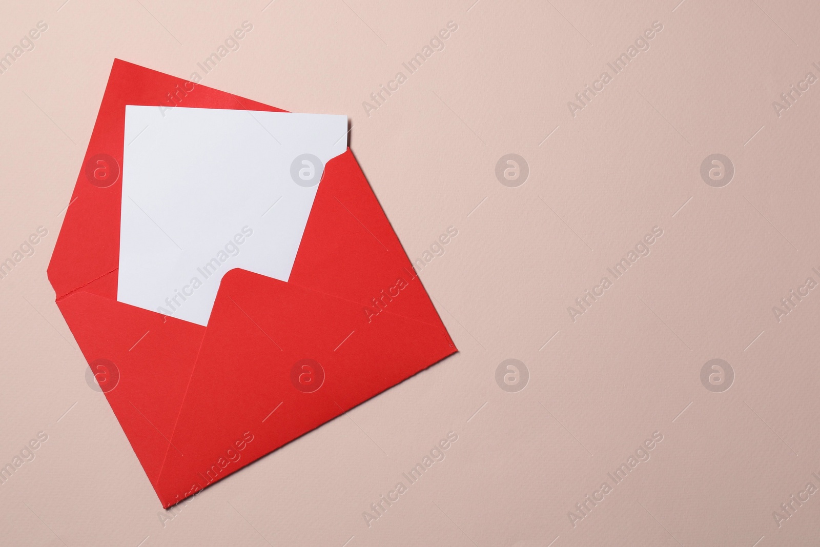 Photo of Letter envelope with card on beige background, top view. Space for text