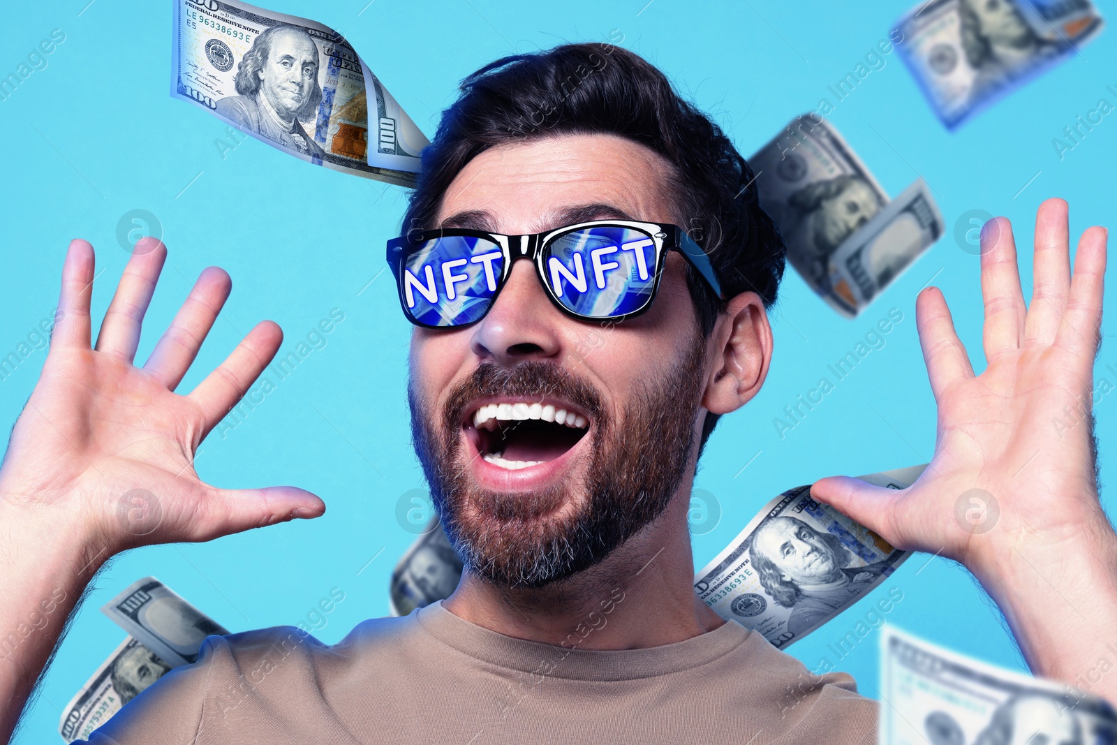 Image of Excited man under money shower on light blue background. Abbreviation NFT reflecting in sunglasses