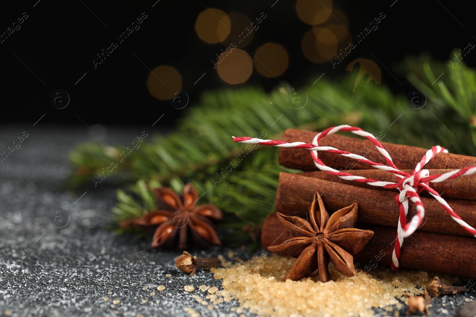 Photo of Different aromatic spices on grey textured table, closeup. Space for text