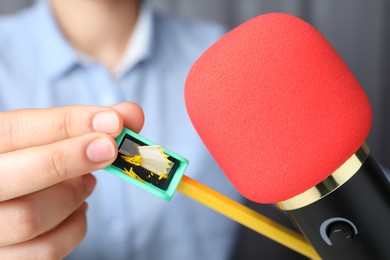 Photo of Woman making ASMR sounds with microphone, pencil and sharpener, closeup