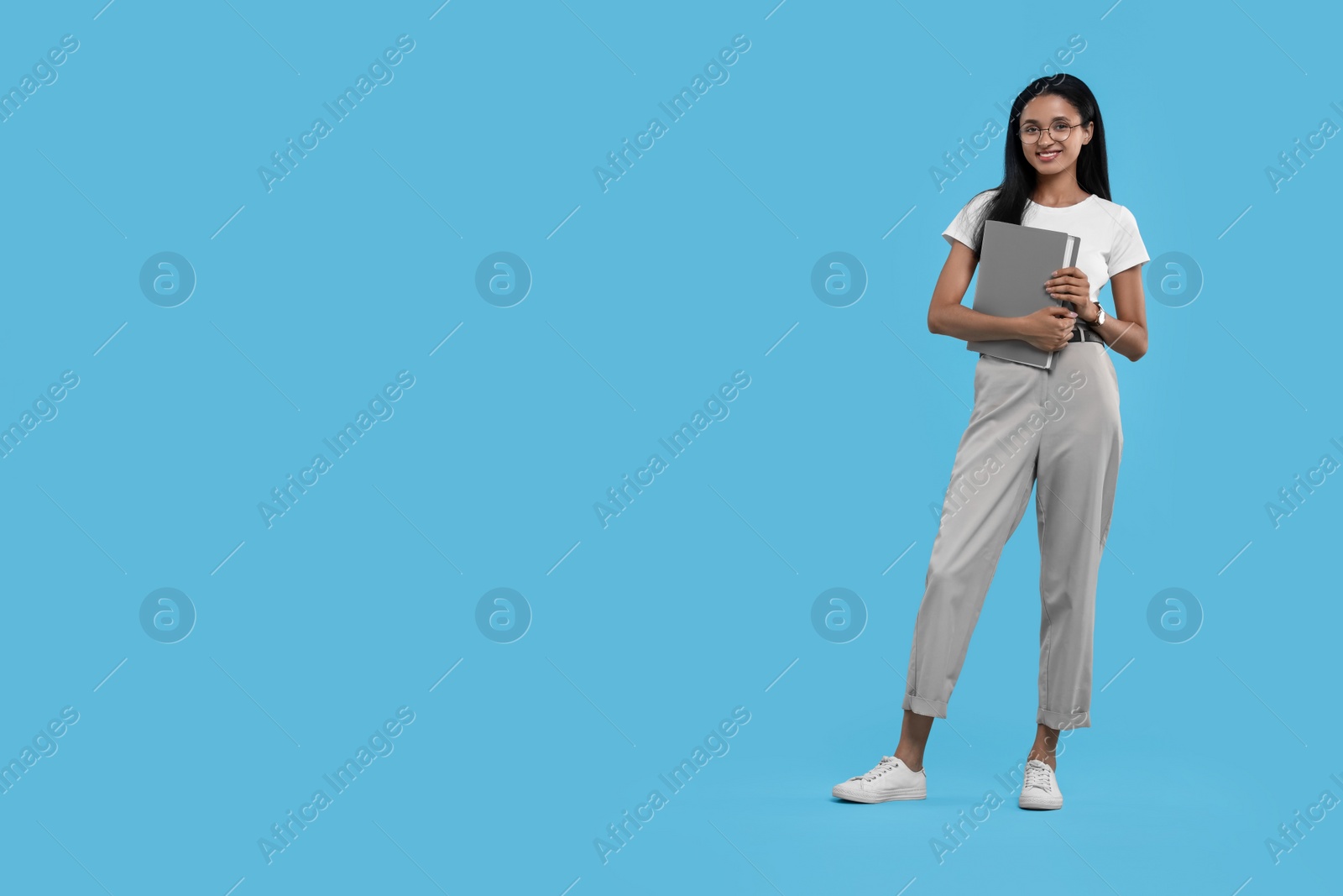 Photo of Beautiful secretary with folder on light blue background, space for text