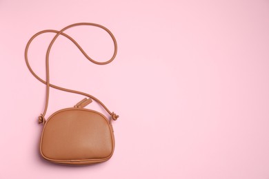 Photo of Stylish woman's bag on pink background, top view. Space for text