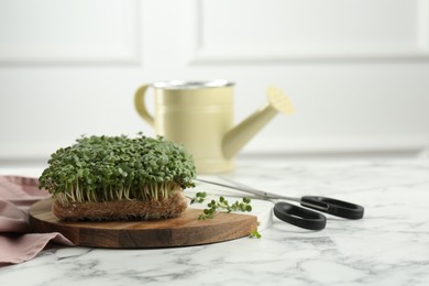 Fresh daikon radish microgreen and scissors on white marble table. Space for text