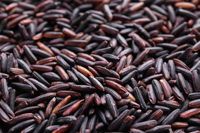 Photo of Uncooked organic brown rice as background, closeup