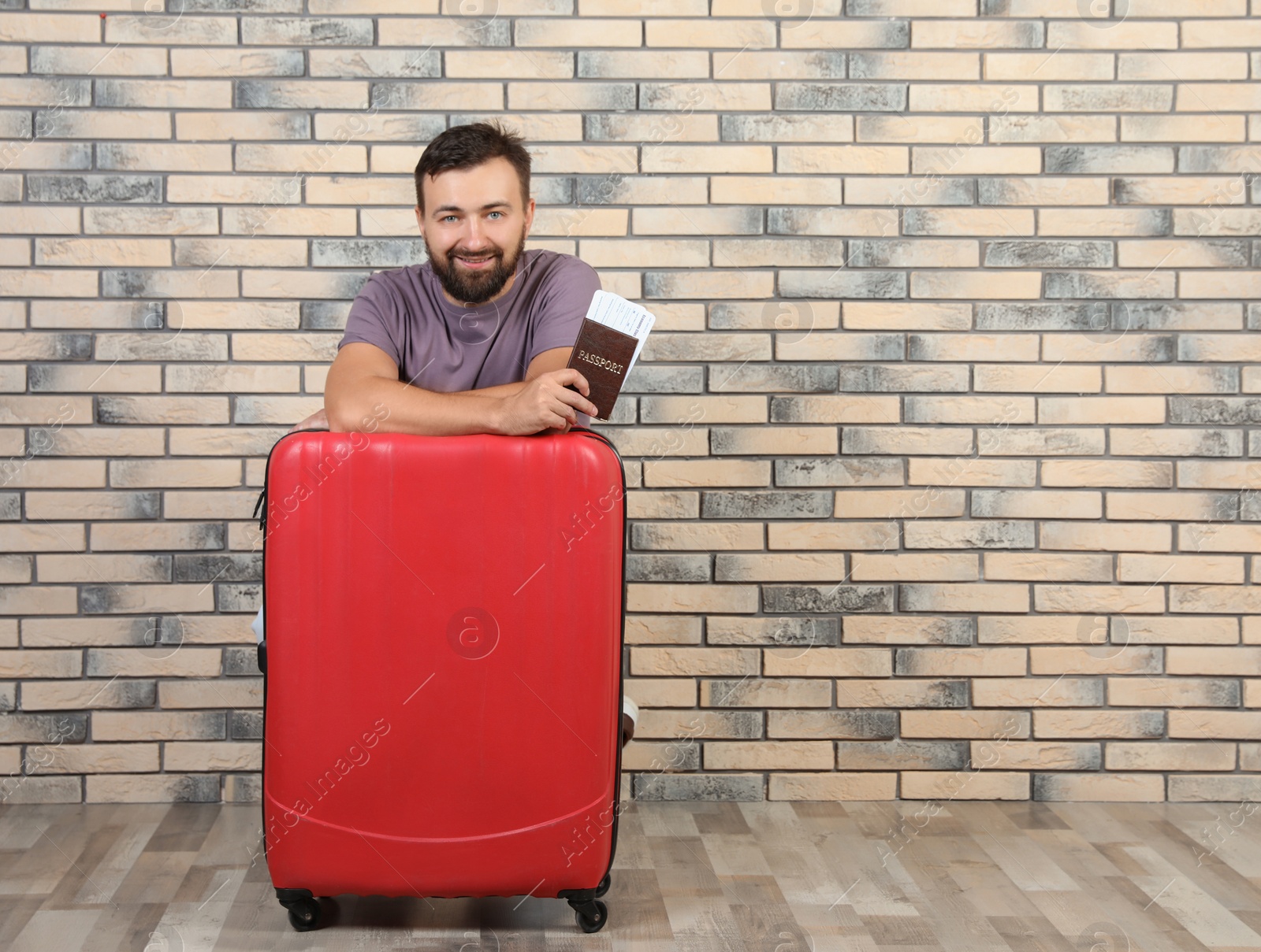 Photo of Man with suitcase and passport near brick wall. Space for text