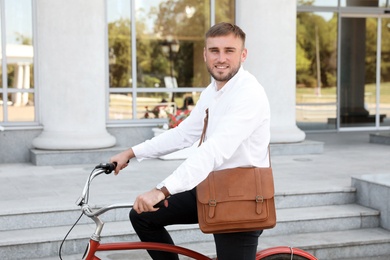 Attractive man riding bike on city street