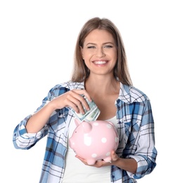 Portrait of happy young woman with money and piggy bank on white background