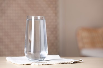 Photo of Glass of pure water on table indoors, space for text