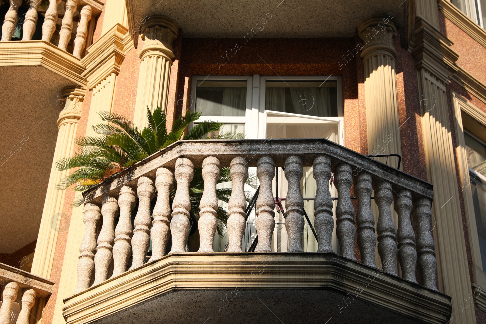 Photo of Exterior of beautiful building with balcony and palm tree outdoors, low angle view