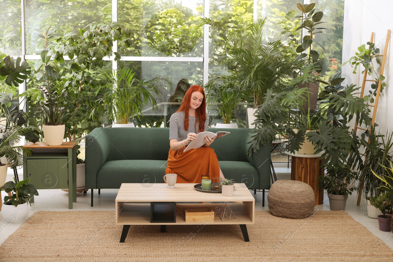 Photo of Beautiful woman reading magazine on sofa in room