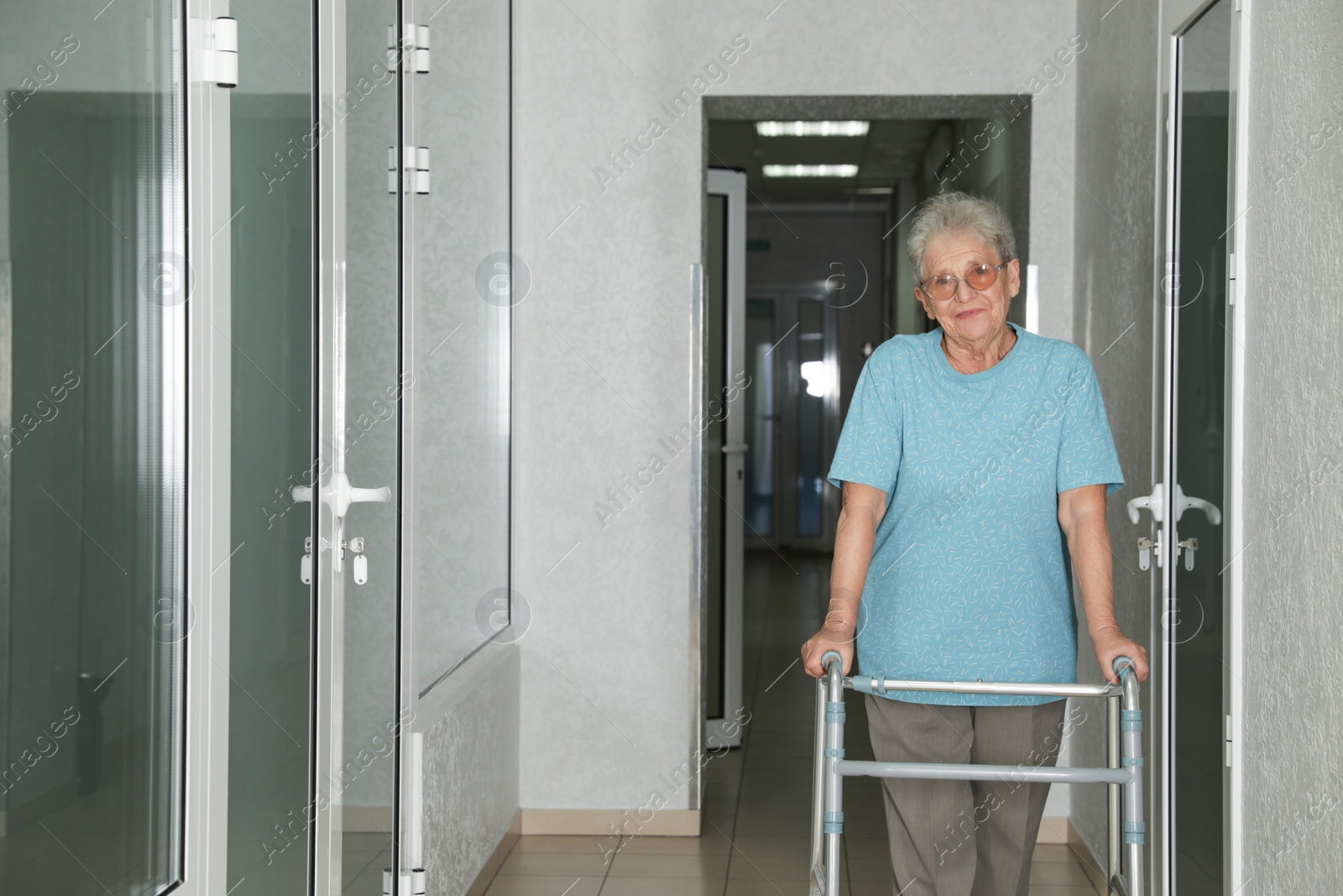 Photo of Portrait of senior woman with walker in hospital hallway