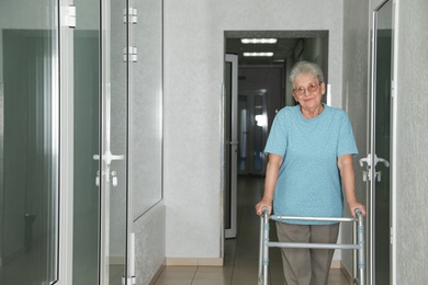 Photo of Portrait of senior woman with walker in hospital hallway