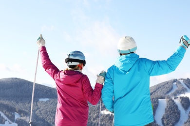 Photo of Couple with ski equipment spending winter vacation in mountains