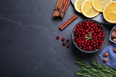 Flat lay composition with fresh ripe cranberries on dark grey table. Space for text
