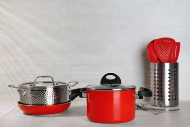 Set of clean cookware on table against light background