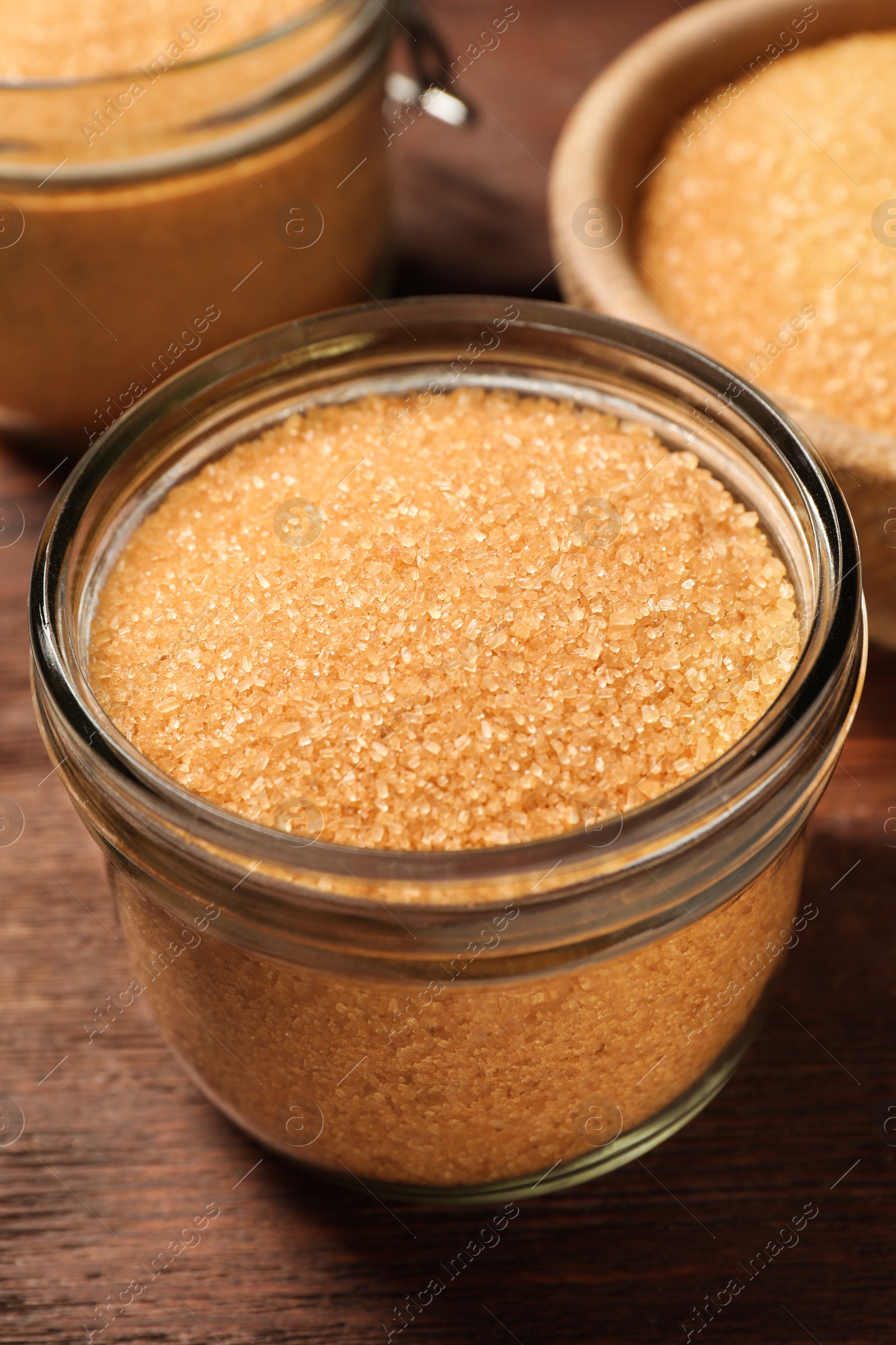 Photo of Different dishes with brown sugar on wooden table, closeup